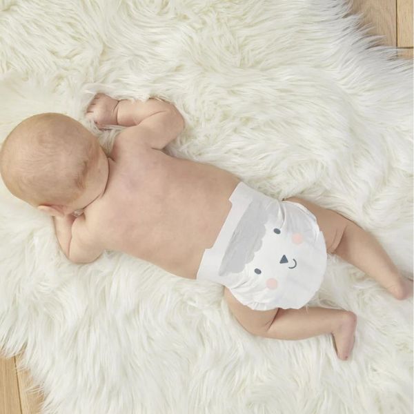 Picture of a baby on a sheepskin rug, wearing kit & kin nappies